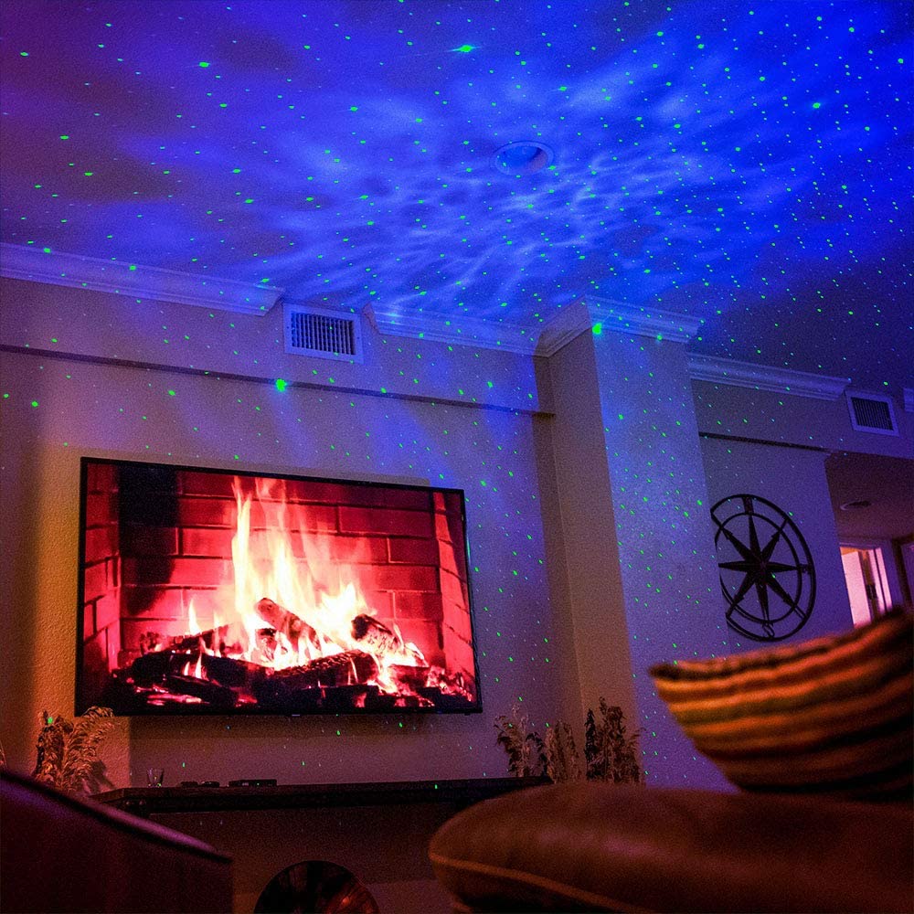 Living room with a TV displaying a fireplace, ceiling projector casting blue and green lights, and a starry night effect.