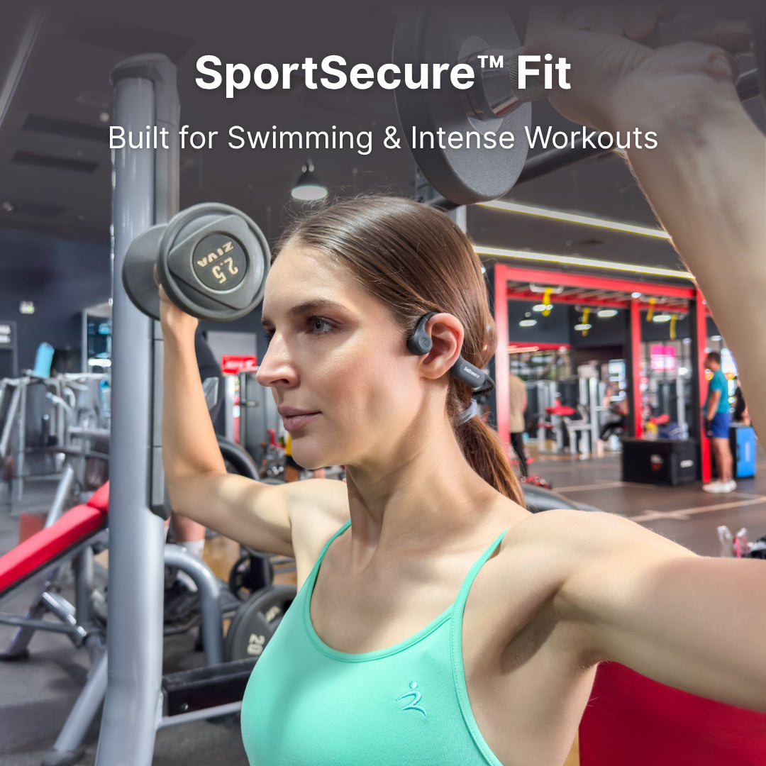 Woman exercising with dumbbells in a gym while wearing bone conduction headphones