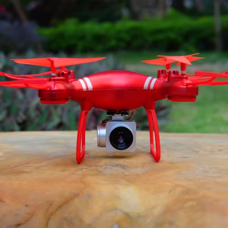 Red drone with a camera on a wooden surface outdoors