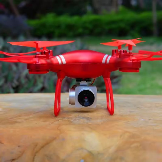 Red drone with a camera on a wooden surface outdoors